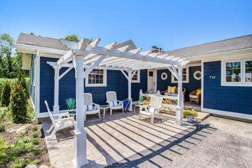 a wooden deck with chairs and a white pergola at Surf's Up in New Buffalo