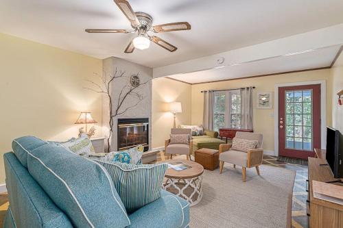 a living room with a blue couch and a ceiling fan at Painted Porch Cottage in Lakeside