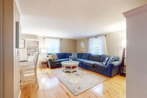 a living room with a blue couch and a table at Life's Better at the Beach in Eastham