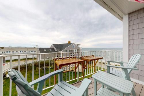 a balcony with chairs and a table and the ocean at Villa Balena - A Cape Cod Oasis in Dennis Port