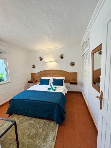 a bedroom with a large bed with a blue blanket at Casa Gatu Verdi-Garden Apartment with Pool in Carvoeiro