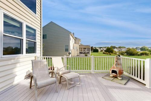 a porch with two chairs and a dog sitting on it at Wedgefield --- 23 Wedgefield in Ocean View