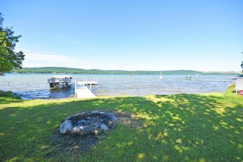 a fire pit in the grass next to a lake at Thorogood Glen in Empire