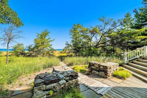 a set of stairs and a stone wall next to a wooden deck at Blue Bear in Glen Arbor