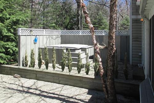 a backyard with a fence and a table with plants at Azure Forest Pool House in Union Pier
