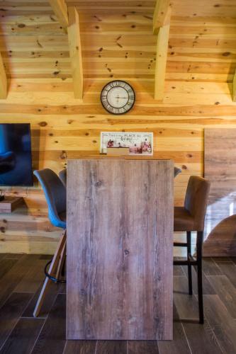 a wooden table with chairs and a clock on the wall at Bugen Villa II in Žabljak