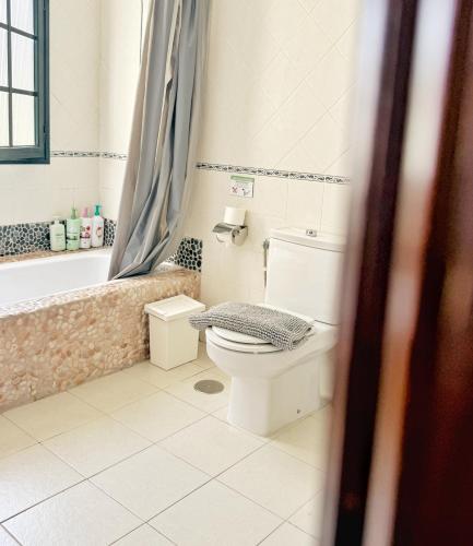 a bathroom with a toilet and a bath tub at Casa Lava in Punta Mujeres