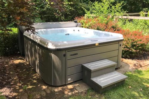 a hot tub sitting in a yard with steps at Borrowed Thyme in Saugatuck