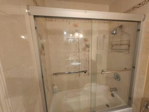 a shower with a glass door in a bathroom at Urban Retreat -Suite A in San Jose