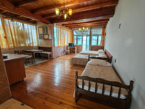 a bedroom with two beds and a kitchen with a table at Lana Seafront Apartments in Šušanj
