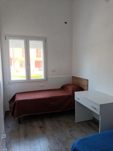 a small bedroom with a bed and two windows at Appartamento Montevago Centro in Montevago
