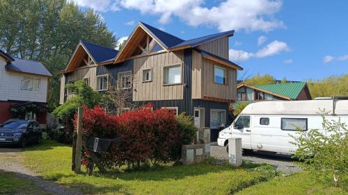 a house with a white van parked in front of it at Cabaña con costa de arroyo in San Martín de los Andes