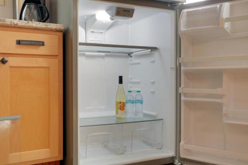 an open refrigerator with a bottle of wine in it at Pet-Friendly Loft Vacation Rental w/ Fire Pit! in Bemus Point