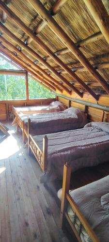 a room with four beds in a log cabin at Cabañas Manantiales de Obligado in San Pedro