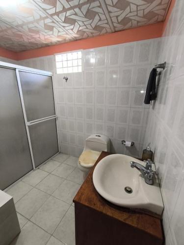 a bathroom with a shower and a sink and a toilet at Casa Finca la Casona con Piscina Privada - Cerca al Parque Tayrona in Santa Marta