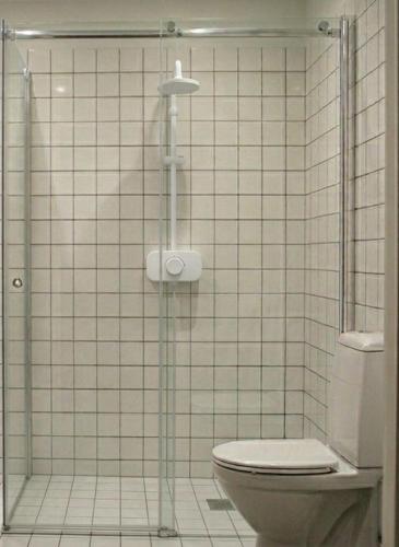 a bathroom with a toilet and a glass shower at Eco Hostal Yuaiurú 2 in Trairi