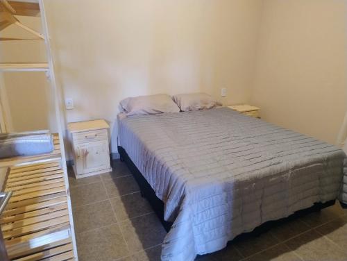 a small bedroom with a bed and a ladder at FiNCA DACA in Junín