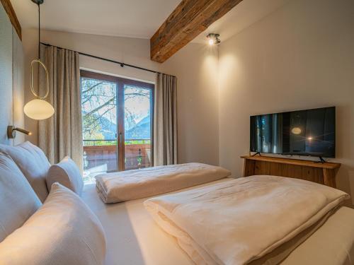 a living room with two beds and a flat screen tv at Die Kramerei in Hollersbach im Pinzgau
