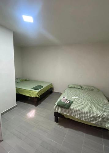 a room with two beds in a room with a ceiling at Casa alexander 4 in Acapulco