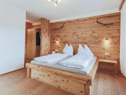 a bed in a room with a wooden wall at Igl Hof Top 2 in Westendorf