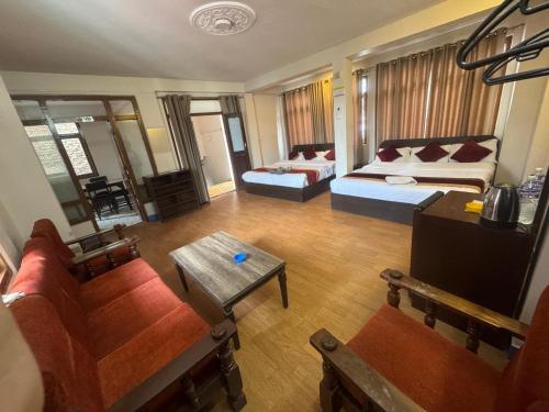 a living room with two beds and a table at Hotel Silver Jubilee in Kathmandu