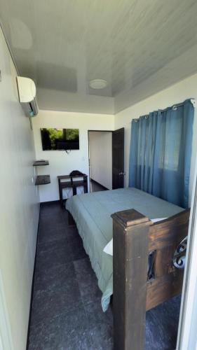 a bedroom with a bed and a table in it at One Piece in Golfito