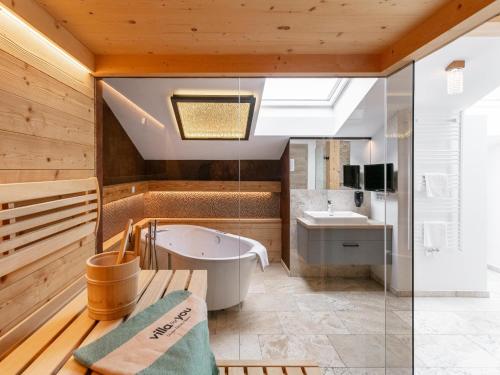 a bathroom with a tub and a sink at Apart33 Top 1-33 Penthouse in Haus im Ennstal