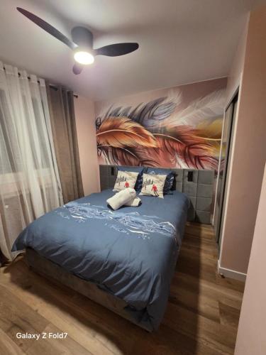a bedroom with a bed with a painting on the wall at JOLYKa résidence avec caméra et digicode possibilité location voiture Mercedes, garage ,climatisation ,cheminée, Netflix, petit déjeuner ,repas du soir fondue, raclette, barbecue sur demande in Albertville