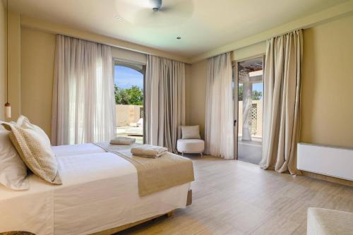 a bedroom with a bed and a large window at Villa Lavender by Villa Plus in Kolymbia