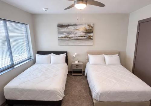 two beds sitting next to each other in a bedroom at Golden Fern Escape in Des Moines