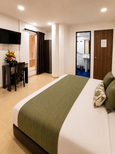 a hotel room with a large bed and a desk at Raí home in Medellín