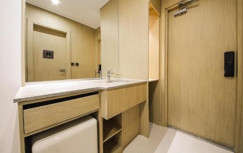 a bathroom with a sink and a mirror at Busan Seomyeon Nestly Hotel in Busan