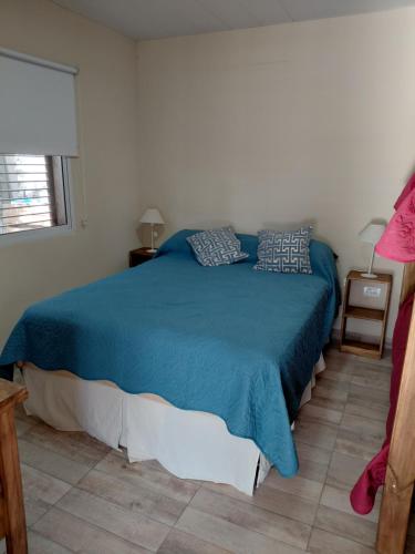 a bedroom with a blue bed with pillows on it at Quinta El Encuentro Junín in Junín