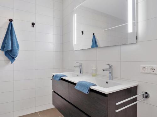 a bathroom with a sink and a mirror at De Havenkamer in Kamperland