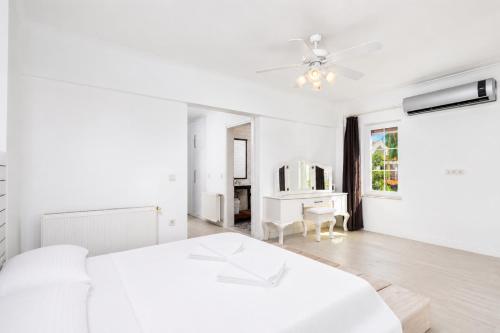 a white bedroom with a bed and a desk at Villa Crystal in Dalyan