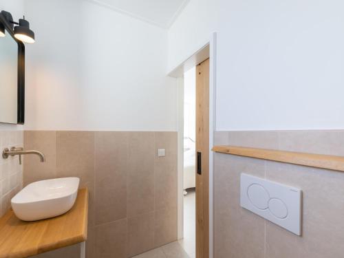 a bathroom with a white toilet and a sink at Duinsuite in Oostkapelle