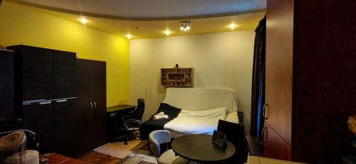 a small room with a bed and a table at Modest Ultra Central Apartment Council Square in Braşov