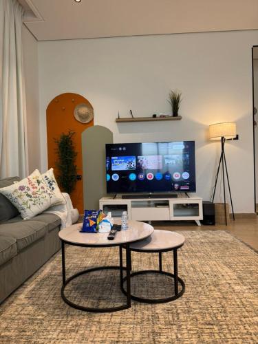 a living room with a tv and a coffee table at شقة الدانة وصول ذاتي القيصومه in Hafr Al-Batin