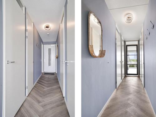a hallway with blue walls and a mirror at De Havenkamer in Kamperland