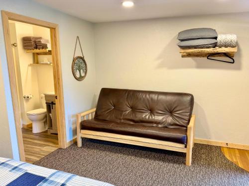 a brown leather couch in a room with a bathroom at Mountain View Lodge & Cabins in Hill City