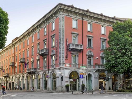 a large brick building on the corner of a street at Mercure Bergamo Centro Palazzo Dolci in Bergamo