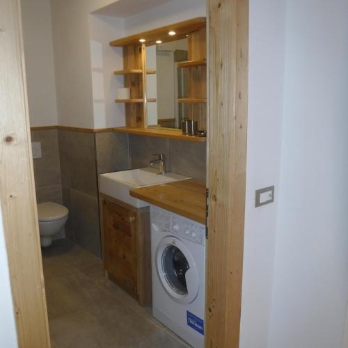 a bathroom with a washing machine and a sink at Appartamento Mariastella in Andalo