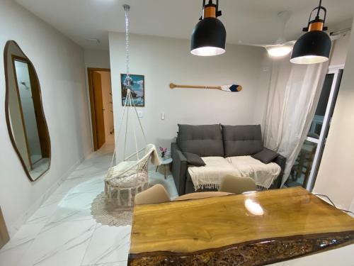 a living room with a couch and a table at Atlântico 33 Guilhermina in Praia Grande