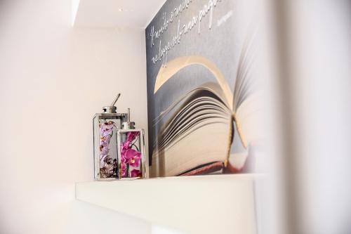 a book sitting on a shelf next to a clock at F53 Kevin's Charming Houses in Alghero