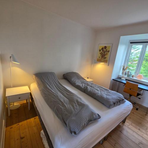 a bedroom with a bed and a window at Bjerregade Horsens Centrum in Horsens