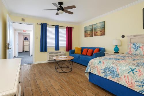 a bedroom with a bed and a blue couch at Ocean Front 53 Steps in Myrtle Beach