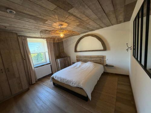 een slaapkamer met een bed en een houten plafond bij Saintbarth in Houyet