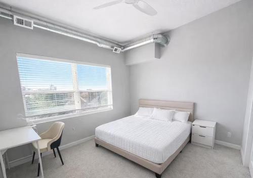 a bedroom with a bed and a desk and a window at Casa Marigold in Des Moines
