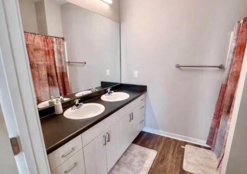 a bathroom with two sinks and a large mirror at Casa Marigold in Des Moines