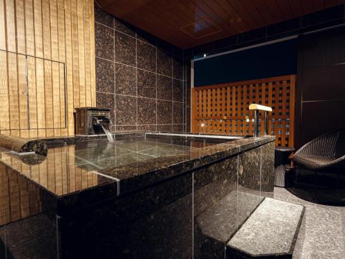 a bathroom with a stone counter with a sink at Hanabishi Hotel in Hakodate
